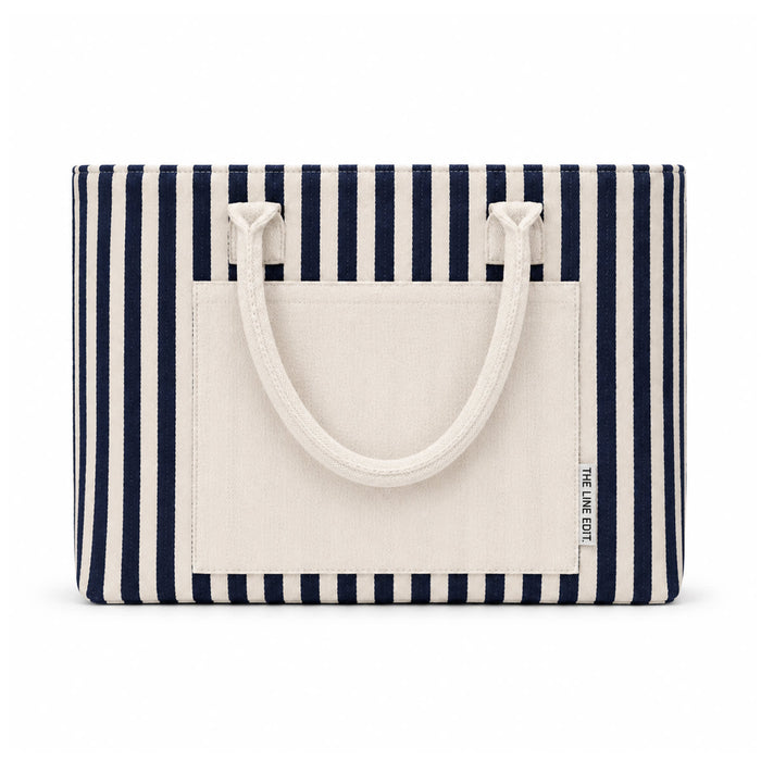 Hampton Tote Bag by The Line Edit. - A striped tote bag featuring navy and cream colours, with a flat pocket and sturdy handles. It has a logo.