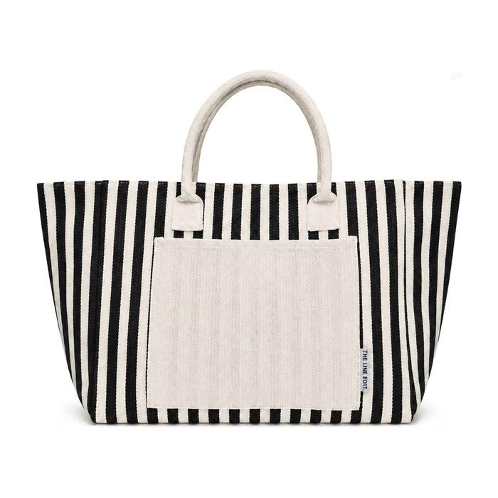 The Sun & Sip Gift Set - A striped tote bag in black and white with a plain cream-coloured front pocket and handles. It has a logo.