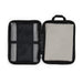 The Hustle Pack - A zipped storage case featuring a mesh pocket and a padded compartment, primarily in black with a light grey interior.