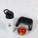 Amore 500ml Junior Bottle - Free Flow Lid - A drink bottle in white with a black lid, accompanied by a red apple and a black gaming controller.