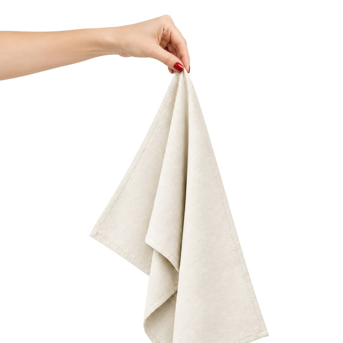 Haven Medium Cotton Tea Towel - A hand holds a light beige cotton tea towel, showcasing its soft fabric and folded design.