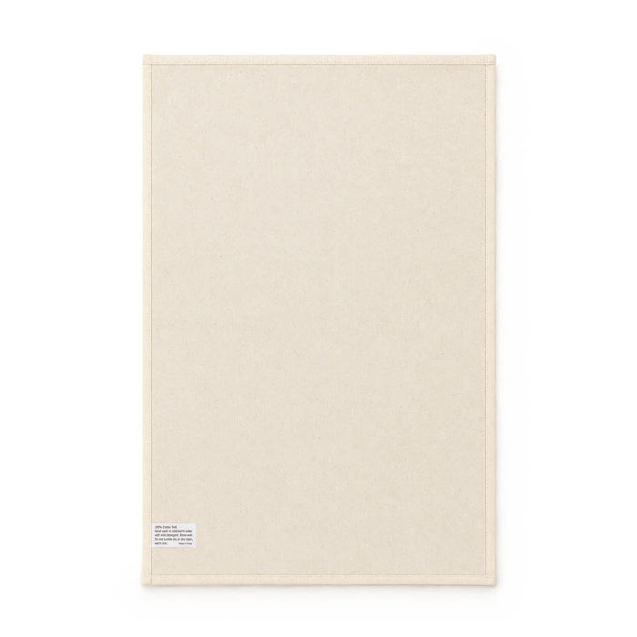 Haven Medium Cotton Tea Towel - A medium cotton tea towel in a cream colour, featuring a small tag and a simple, plain design.