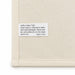 Haven Medium Cotton Tea Towel - A cream cotton tea towel featuring a care label with washing instructions and a brand logo.