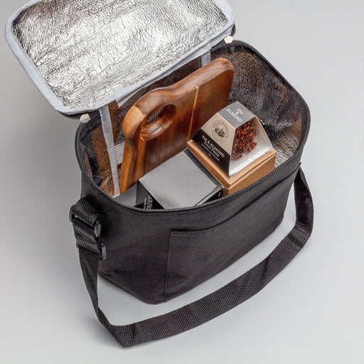 The Carry-On Graze - A black cooler bag with a silver insulated interior, containing a wooden cutting board and packaged food items.