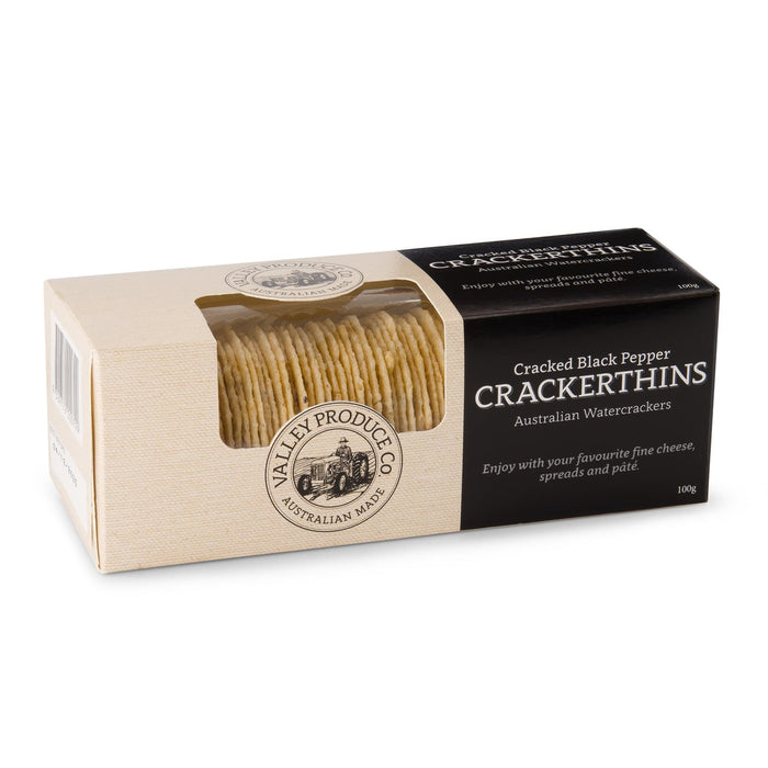 The Refined Graze - A box of Cracked Black Pepper Crackerthins featuring a stack of thin water crackers. The box has a logo and a beige colour scheme.