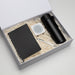 The Daily Setup - A black drink bottle, a notebook, a white speaker, and a pen packed in a gift box with shredded paper.