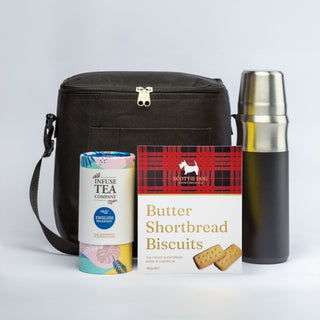 The Brew & Bite - A cooler bag in black, a silver drink bottle, a tin of tea, and a box of butter shortbread biscuits.