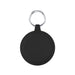 The Ultimate Welcome - Hot Chocolate Edition - A round black keychain holder features a silver keyring. The surface is smooth with subtle grooves around the edge.