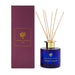 The Generous Host - A reed diffuser with a blue glass bottle, gold lid, and bamboo reeds, packaged in a purple box.