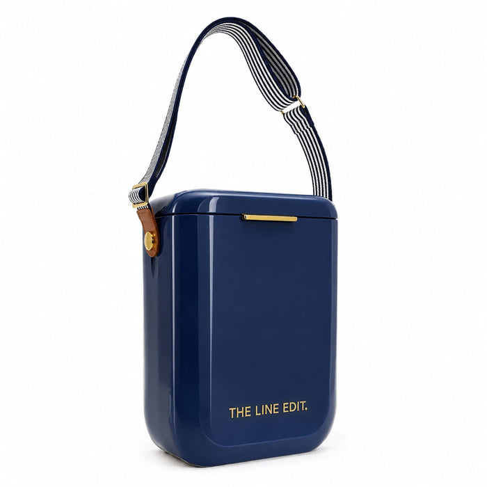 Pavilion Cooler by The Line Edit. - A navy blue cooler with a striped strap and a small logo. It has a sleek, rectangular design.