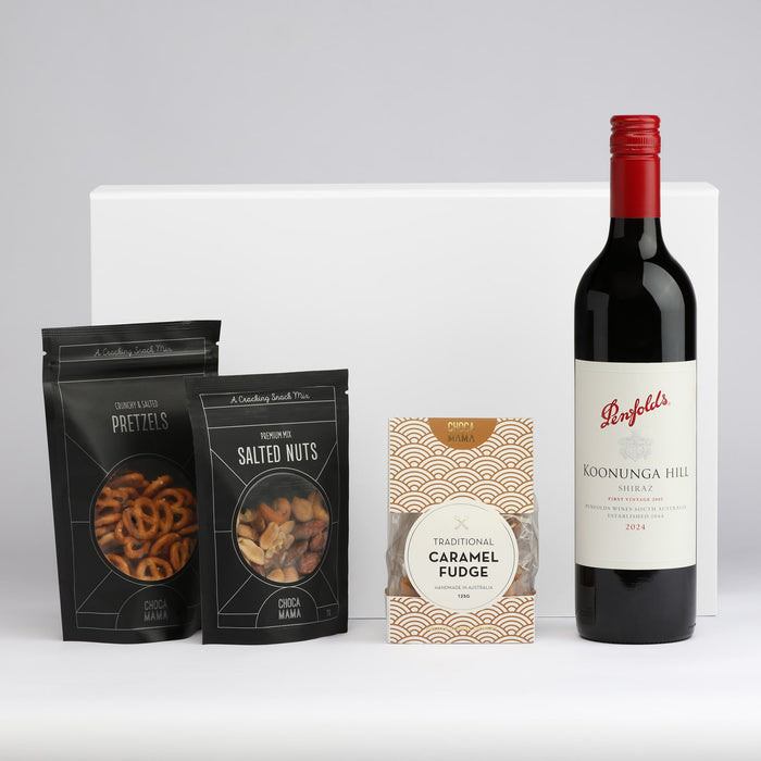 The Perfect Pairing - A drink bottle of red wine accompanied by packets of salted nuts, pretzels, and caramel fudge. All items are elegantly arranged.