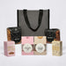 The Treat Kit - A grey cooler bag with assorted snacks: pretzels, beer nuts, marshmallows, traditional coconut ice, caramel fudge, and drinking chocolate.