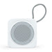 The Escape Pack - A white portable speaker with a round mesh grille and a fabric strap. The design is minimalist and compact.