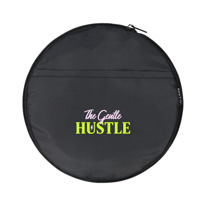 The Hustle Pack - A round black bag with a zip closure, featuring a colourful logo that includes the words "The Gentle Hustle."