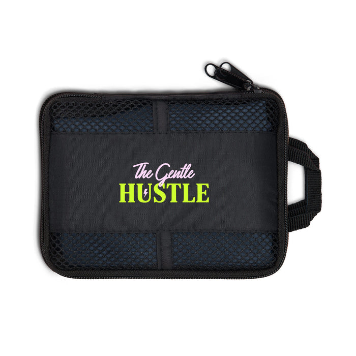 The Hustle Pack - A black zipped pouch featuring a mesh pocket and a logo. It has a handle for easy carrying.