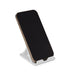 Glide Phone Stand - A phone in a white Glide Phone Stand, featuring a simple design with an adjustable angle.
