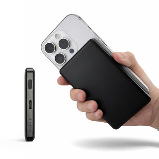 Axial by Nomis Solid State Power Bank - A black power bank held in one hand, with a smartphone partially visible in the background.