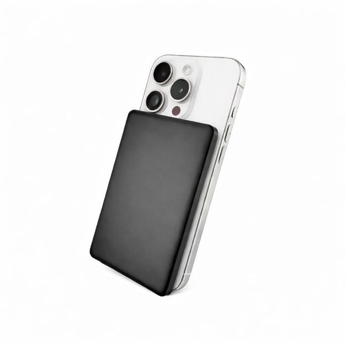 Axial by Nomis Solid State Power Bank - A black solid-state power bank is positioned against a silver smartphone, highlighting its sleek design and portable size.
