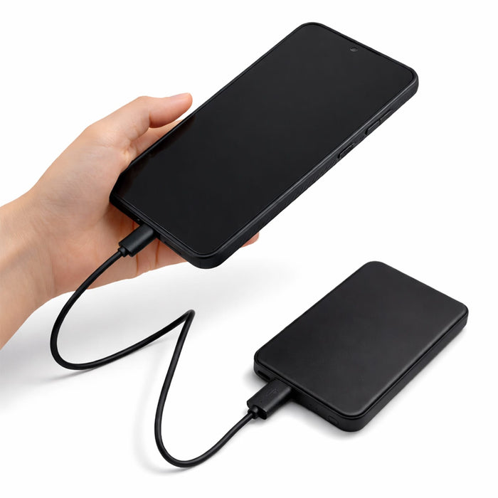 Dynamo Solid State Power Bank - A black solid state power bank with a charging cable connected, held in a hand.