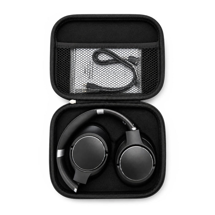 Aero by Nomis Headphones - A pair of black wireless headphones packed in a compact black carrying case, with a charging cable inside.