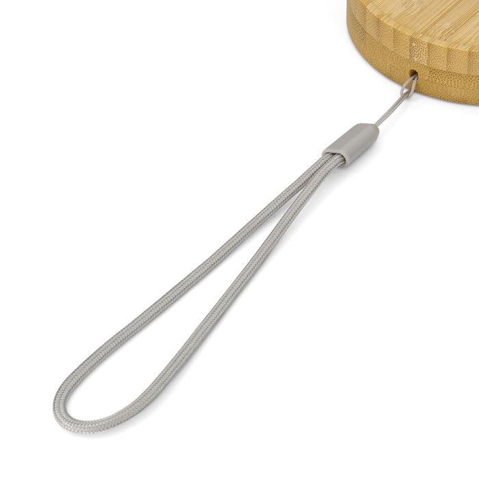 Reveal Circle Wireless Charger Set - A close-up of a bamboo wireless charger with a grey strap included for easy handling. It features a logo.