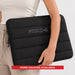 Bubble Neoprene Laptop Sleeve 16 inch - A black neoprene laptop sleeve, featuring a padded design and a logo, held by a person. More colours available.
