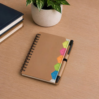 Calton Sticky Note Memo - A brown spiral notebook sits on a wooden surface, accompanied by a pen and vibrant sticky notes in various colours.