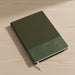 Murica Notebook B5 - A black B5 notebook with a ribbed cover, resting on a wooden desk, featuring a ribbon bookmark.
