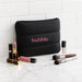 Bubble Neoprene Cosmetic Bag - A black neoprene cosmetic bag with pink branding, surrounded by various lip products and makeup brushes.