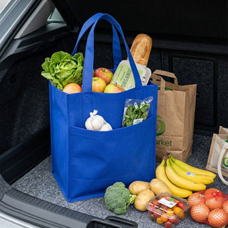 Pocket Shopping Bag - A blue shopping bag filled with lettuce, apples, bread, vegetables, and other groceries in a car boot.