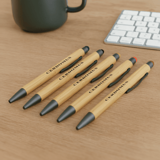 Manopoli Bamboo Pen - A set of bamboo pens in natural wood and black, featuring a logo, displayed on a wooden surface.