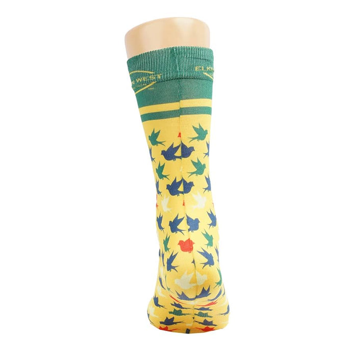 Magic Dress Socks - Bright yellow socks featuring a leaf pattern in green, red, and blue, with a green cuff and branding on top.