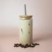 Carnaby 500ml Tumbler - A drink bottle with a bamboo lid and stainless steel straw, filled with a creamy iced beverage and surrounded by coffee beans.