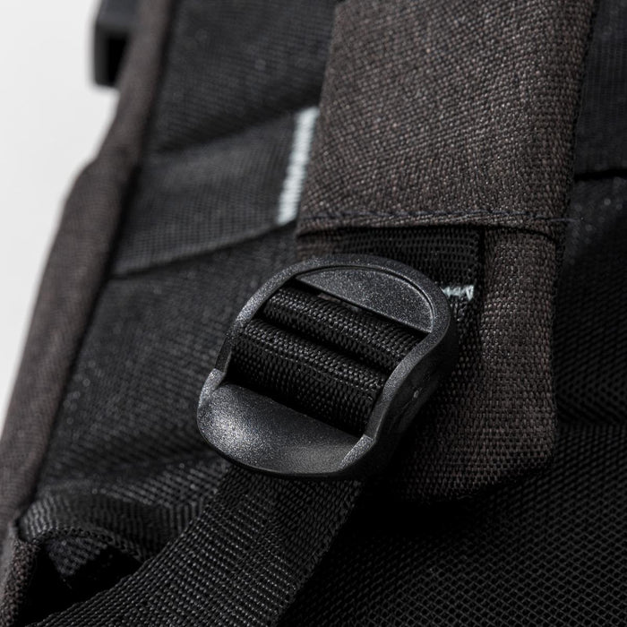 Swissdigital Arosa Backpack - A close-up of a black backpack strap buckle with textured fabric in the background. The backpack has a logo.