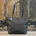 Swissdigital Arosa Tote Bag - A dark grey tote bag with black handles and a subtle logo on the side, featuring a zip closure.