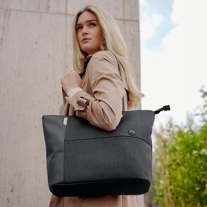 Swissdigital Arosa Tote Bag - A woman carries a stylish black and grey tote bag with a logo, set against an outdoor background.