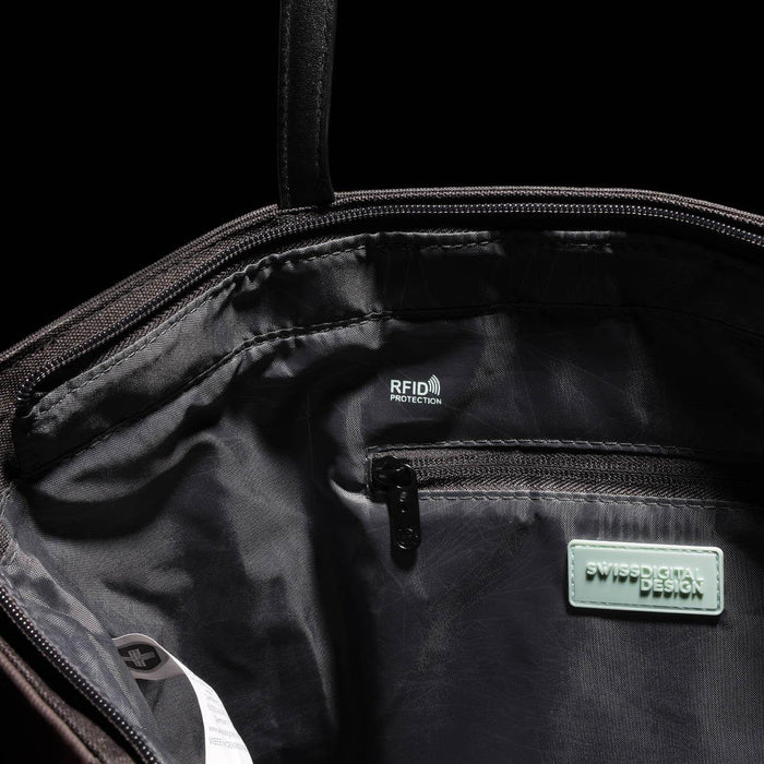 Swissdigital Arosa Tote Bag - An interior view of a black tote bag featuring RFID protection, a zip pocket, and branding.