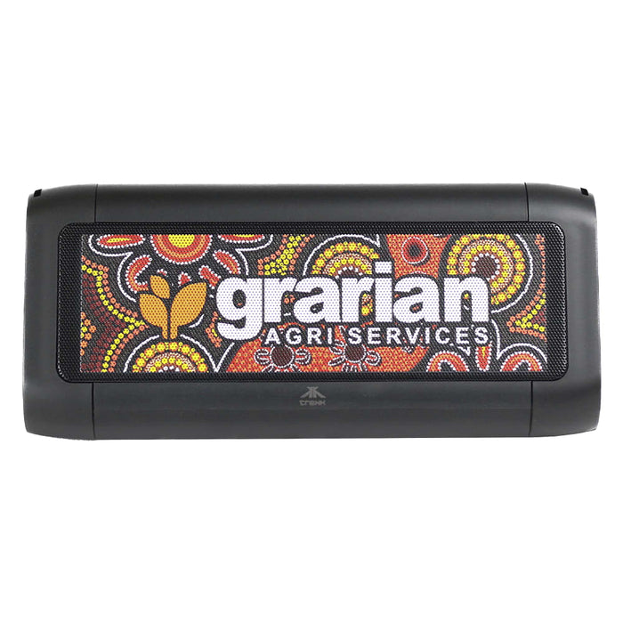 Trekk Outdoor Speaker & Wireless Powerbank - A black outdoor speaker featuring a vibrant Aboriginal art design and a logo. Suitable for outdoor use and charging devices.