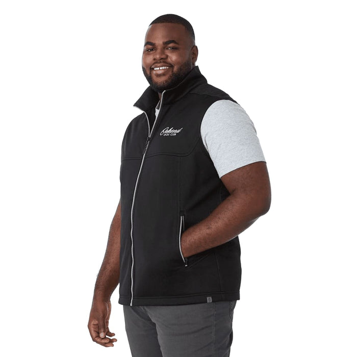 Men's Joris Eco Waterproof Softshell Vest - A black eco waterproof softshell vest with a zip front, featuring a logo, worn by a smiling man.
