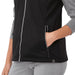 Women's Joris Eco Waterproof Softshell Vest - A black women's softshell vest featuring a zip front and side pockets, with grey sleeves and a branding logo.