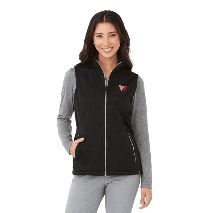 Women's Joris Eco Waterproof Softshell Vest - A black women's softshell vest with a zip front, featuring a logo, worn over a grey long-sleeve top.