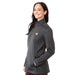 Women's Joris Eco Waterproof Softshell Jacket - A woman wearing a grey softshell jacket with a logo, featuring a zip-up front and side pockets.