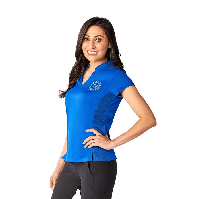 Women's Piedmont Short Sleeve Performance Polo - A woman wearing a blue short sleeve performance polo shirt with a logo on it, paired with black pants.