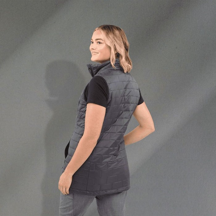 Women's Telluride Lightweight Packable Insulated Puffer Vest - A woman wearing a grey lightweight packable insulated puffer vest, showcasing a side view with a smooth background.
