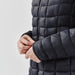 Women's Tundra Thermal Jacket - A women's puffer jacket in black, featuring a quilted design and a close-up of the cuff with a logo.