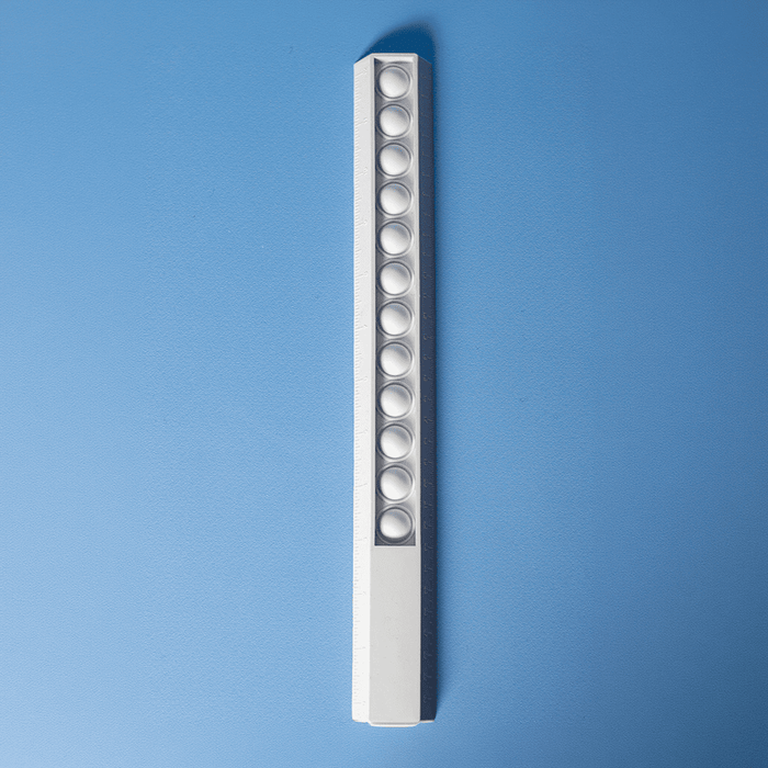 30cm Popper Ruler - A white 30cm popper ruler featuring multiple poppers along its length, set against a blue background.