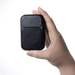The Rebel Clip Speaker - A compact black speaker held in one hand, featuring a textured front and smooth back, with a logo present.
